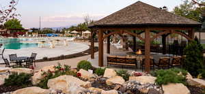 View of community featuring a gazebo, a swimming pool, an outdoor fire pit, a patio area, and a mountain view
