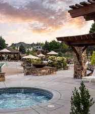 Pool at dusk with a gazebo, a patio, and a hot tub
