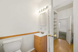 Bathroom featuring toilet, vanity, and wood-type flooring