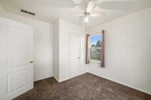 Bedroom 2 featuring dark colored carpet, baseboards, and ceiling fan