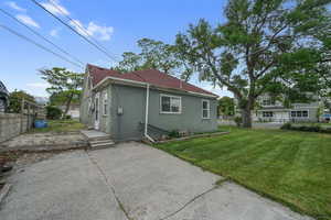 Back of house with a shingled roof, a patio area, and stucco siding