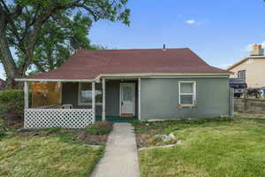 View of front of home with stucco siding, covered porch