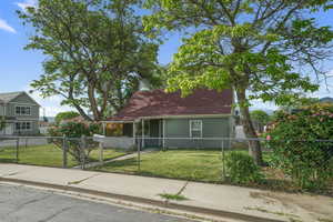 View of front of house featuring covered porch and mature trees