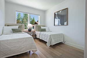 Bedroom with wood finished floors and baseboards