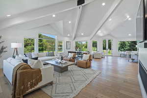 Living area featuring beamed ceiling, light wood-style flooring, recessed lighting, high vaulted ceiling, and french doors