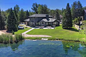 Rear view of house featuring a patio area and a water view