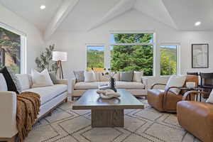 Living area with lofted ceiling and recessed lighting