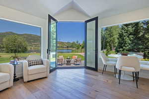 Sitting room featuring hardwood / wood-style flooring, a water view, and vaulted ceiling
