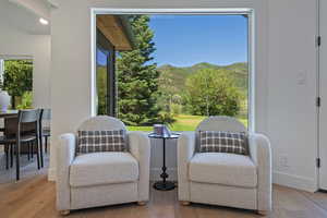 Living area featuring light wood-style floors, a mountain view, and baseboards