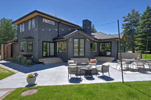 Rear view of property featuring a patio, a chimney, and entry steps