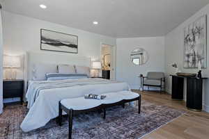 Bedroom with light wood-type flooring, baseboards, and recessed lighting