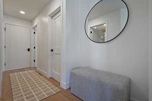 Hall with light wood-style flooring, recessed lighting, and baseboards