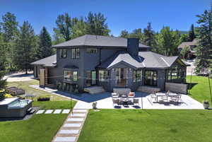 Back of house featuring a patio, a shingled roof, a yard, and an outdoor living space