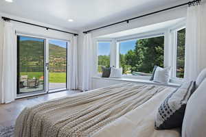 Bedroom featuring access to exterior, multiple windows, wood finished floors, and recessed lighting