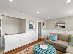 Living area featuring wood finished floors, wainscoting, and recessed lighting