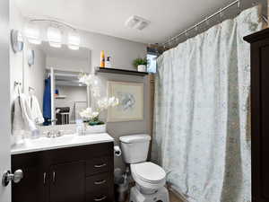 Bathroom with toilet, vanity, and a shower with curtain