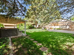 View of yard featuring a hot tub, a patio, and a pergola