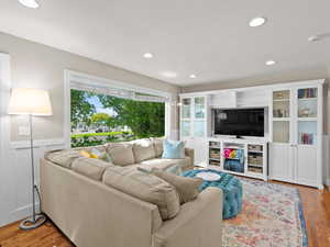 Living room featuring a wainscoted wall, light wood finished floors, and recessed lighting