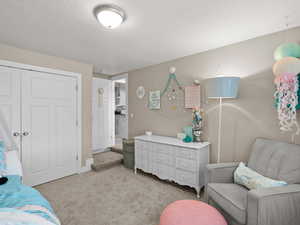 Bedroom featuring light carpet and a closet