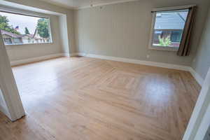 Unfurnished room with baseboards and ornamental molding Notice the original wood floor mosaic  design.