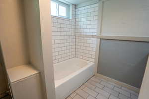 Full bathroom featuring bathtub / shower combination, tile patterned floors, and baseboards