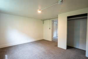 Unfurnished bedroom featuring carpet floors, a closet, and baseboards