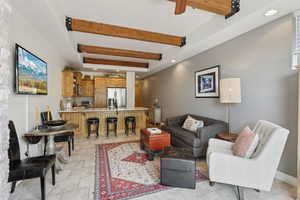 Living area featuring beam ceiling, recessed lighting, and light tile patterned floors