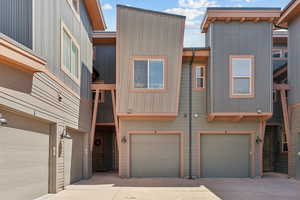 View of front facade with driveway, an attached garage, and board and batten siding