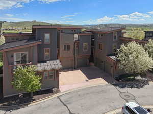 View of front of house featuring a mountain view, a standing seam roof, an attached garage, metal roof, and driveway