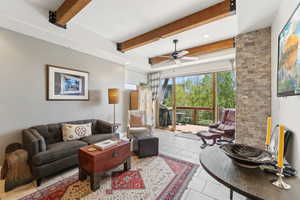 Tiled living room with beamed ceiling, a ceiling fan, and recessed lighting