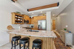 Kitchen with stainless steel appliances, a sink, a peninsula, open shelves, and recessed lighting