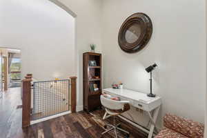 Office space featuring arched walkways and dark wood-type flooring