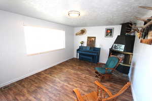 Sitting room with wood finished floors, baseboards, and a textured ceiling