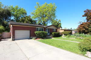 Ranch-style house with a garage, brick siding, and driveway