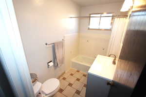 Bathroom featuring toilet, a bath, vanity, and a shower with curtain