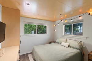 Bedroom with dark wood-style flooring and baseboards