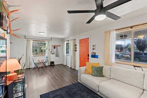 Living area with wood finished floors, ceiling fan, and baseboards