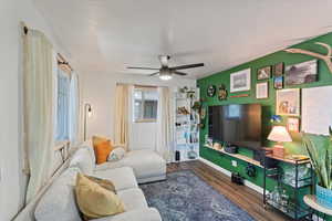 Living room featuring wood finished floors, a ceiling fan, and baseboards