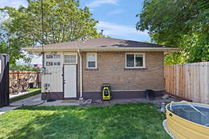 Back of house featuring brick siding and roof with shingles