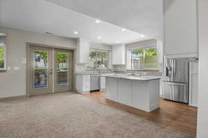 Basement/AUD kitchen featuring white cabinets, stainless steel appliances, wood look tile floors and granite countertops