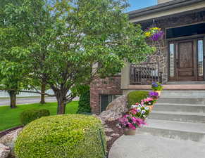 Entrance to property with stone siding and a porch