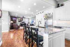 Open kitchen with large island with seating, stainless steel appliances and granite countertops