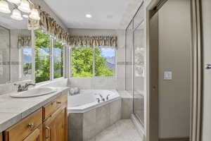 Primary spa style bathroom with oversized jetted tub, double vanity and built in storage cabinet, travertine steam shower with bench.