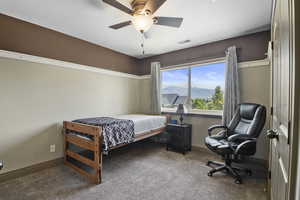 One of 4 upstairs bedrooms with a ceiling fan and a large window