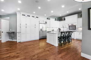 Beautifully updated kitchen with white cabinets, granite countertops. hickory hardwood floors and stainless steel appliances