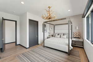 Bedroom with light wood-style flooring, a chandelier, baseboards, and recessed lighting