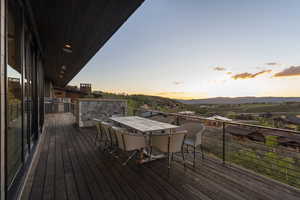 Deck at dusk with a mountain view and exterior kitchen