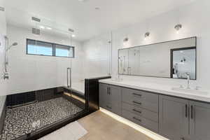 Bathroom featuring a stall shower, double vanity, and a tub