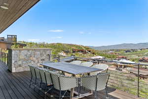 Deck with a mountain view and outdoor dining space
