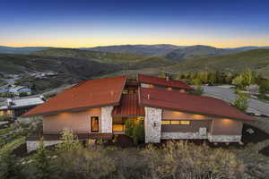 View of front facade featuring a mountain view, stone siding, and a garage
